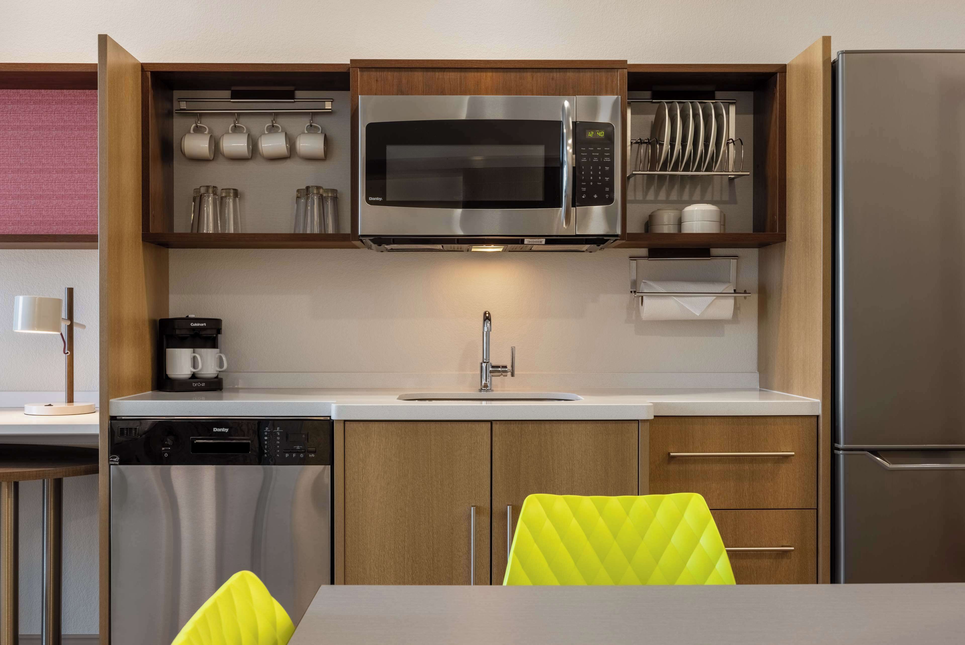 Eine moderne Küche mit Einbau-Mikrowelle, Kaffeemaschine und Geschirrspüler.
