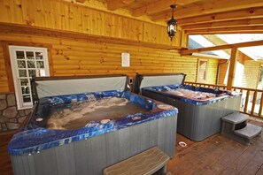 Two hot tubs with wooden walls and a stone wall in the background. - Western Lodge - Huge, w/Heated Pool, Hocking Hills (Logan)