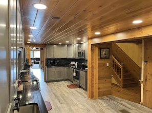 Una cocina con armarios de madera, estufa y microondas.
