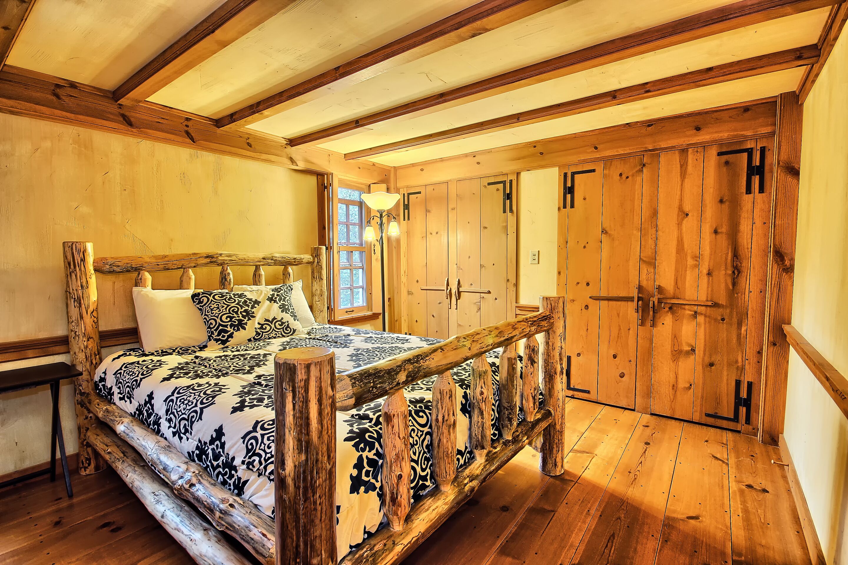 Une chambre à coucher rustique avec un lit en bois, une table de chevet et une fenêtre.