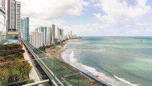 Un paisaje urbano costero con rascacielos, una playa y cielo despejado.