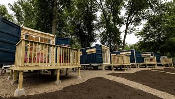 Una fila di cabine modulari con ringhiere in legno e terreno sterrato.
