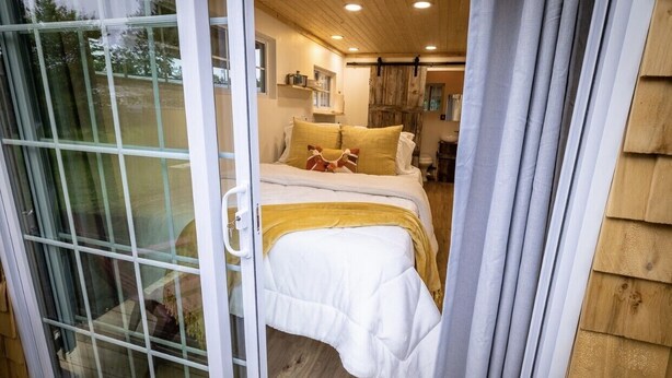 Un dormitorio con cama, ventana y puerta.