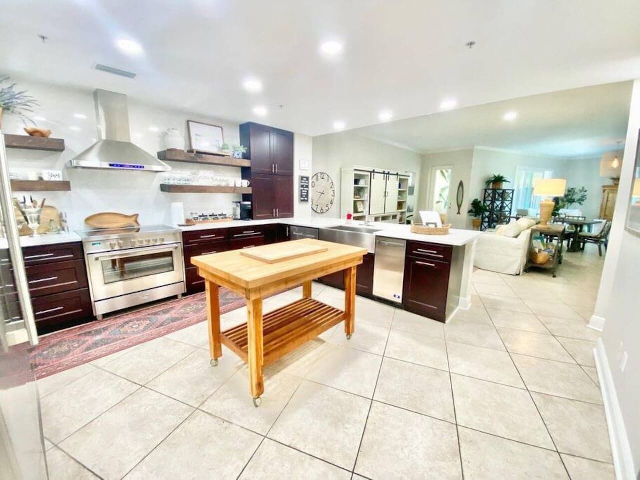 Una cocina moderna con una isla central, electrodomésticos de acero inoxidable y suelo de baldosas.