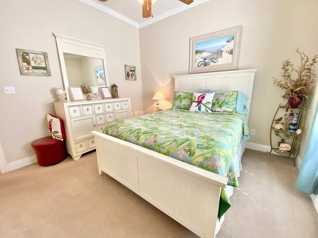 A bedroom with a bed, dresser, and a mirror.