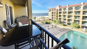 A balcony with a view of a pool and a building with multiple balconies. - #631 Beautiful poolside Condo perfect for a family getaway (Harrison County)