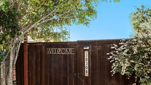 A wooden fence with a 'WELCOME' sign and a mailbox with the number '3830B'.