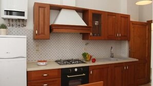 Une cuisine moderne avec des meubles en bois, une cuisinière à gaz et un coin repas comprenant une table et des chaises.