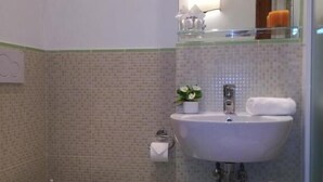 Un baño con inodoro, lavabo y un taburete pequeño.