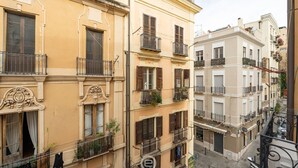 A multi-story building with balconies, large windows, and decorative architectural details.