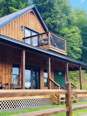 A wooden cabin with a balcony, large windows, and a covered porch area. - Luxury cabin on private drive. Fall foliage at its finest, waterfront access.  (Remsen)