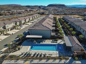 A residential area with a swimming pool, rows of houses, and a mountain in the background. - Top Tier Townhome in Washington Utah Private Spa, Pool, Firepit. VS507 (Washington)