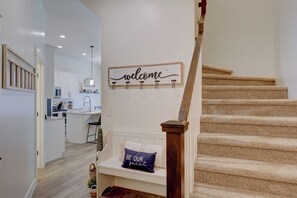 A modern interior with a staircase, a kitchen area, and a welcome sign. - Top Tier Townhome in Washington Utah Private Spa, Pool, Firepit. VS507 (Washington)
