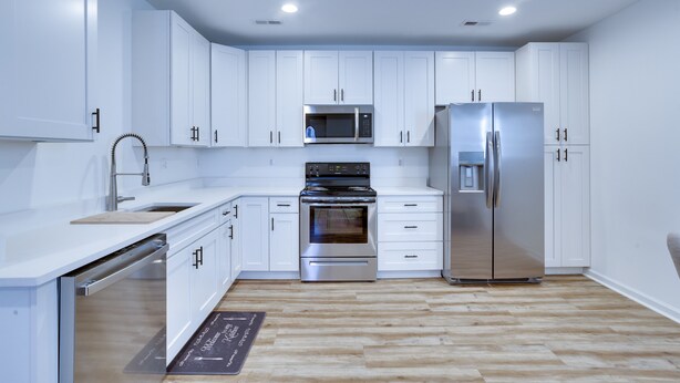 A modern kitchen with white cabinets, stainless steel appliances, and a wooden floor. - Spacious La Plata Escape (La Plata)