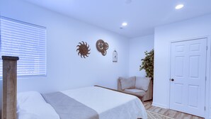 A bedroom with a bed, a chair, a door, and wall decorations. - Spacious La Plata Escape (La Plata)