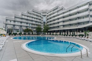A modern hotel with a central swimming pool, multiple balconies, and sun loungers. - TUI SUNEO PERLA ADULTS ONLY (Sunny Beach)