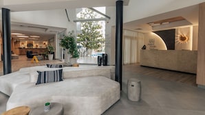 A modern hotel lobby with a reception desk, seating area, and a view of the outdoors. - TUI SUNEO PERLA ADULTS ONLY (Sunny Beach)