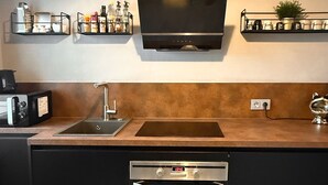 Eine moderne Küche mit Backofen, Spüle und einem Flachbildfernseher über der Arbeitsfläche.