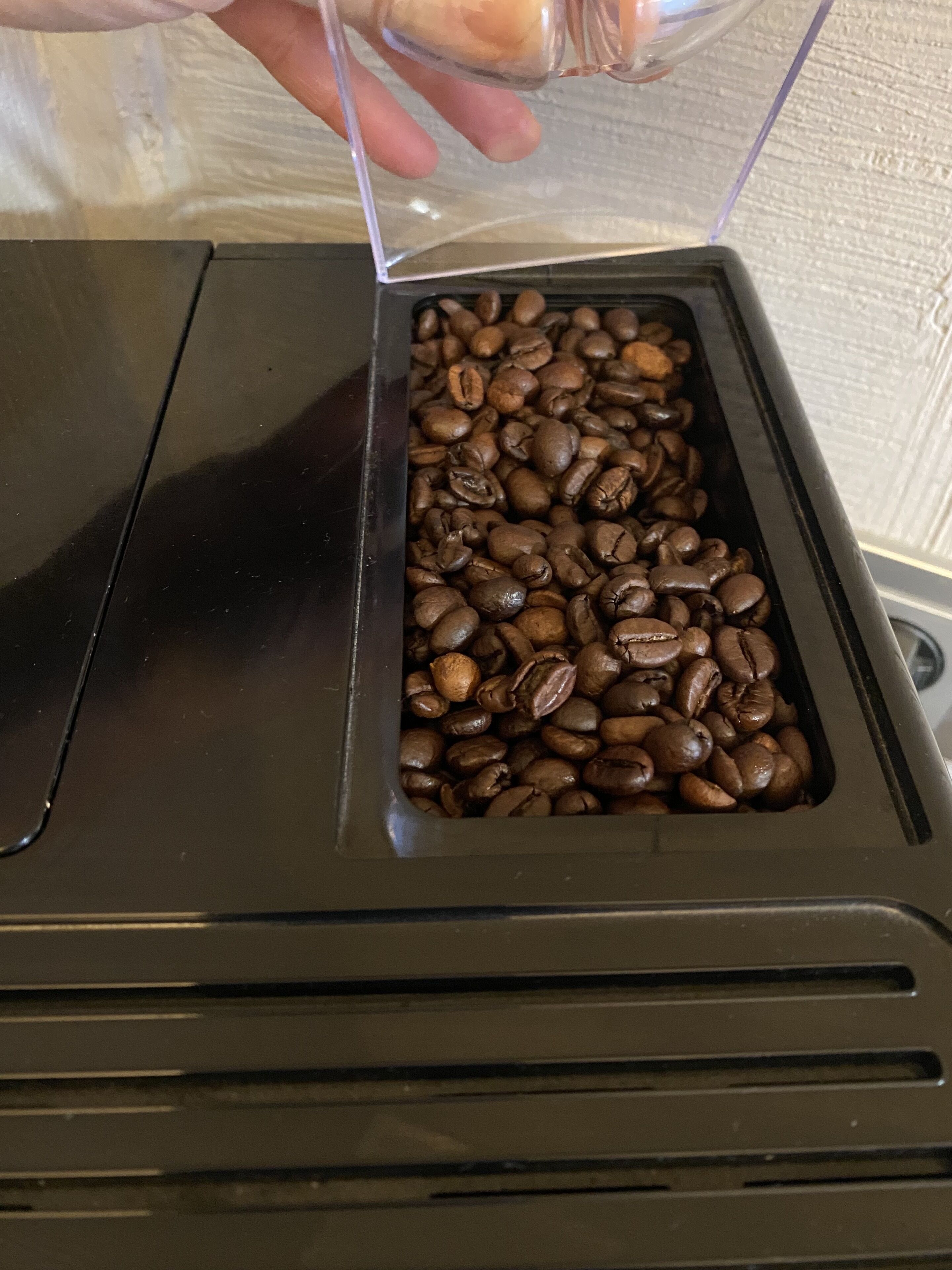 Eine Kaffeemaschine mit einem transparenten Behälter voller Kaffeebohnen.