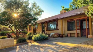 A modern house with a large patio, a stone fireplace, and a well-maintained garden. - Enjoy a Sweet Retreat in Kanab, Utah. Walking distance to all downtown Kanab has to offer. Close to Zion, Bryce Canyon, and the Grand Canyon! (Kanab)