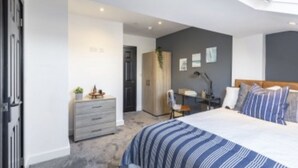 A bedroom with a bed, a desk, and a wardrobe. - The Residency Rooms Liverpool  (Wallasey)