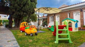A brick building with a play area including a slide and toy cars. - Posada Bernies (Ezeiza)