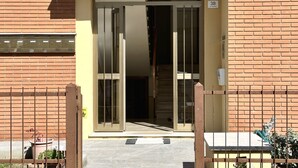 A building entrance with a metal gate, a brick wall, and a number sign '38' on the right. - SE041 - Senigallia,  four-room apartment super equipped 150m from the sea (Senigallia)