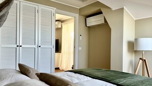 A bedroom with a bed, a wardrobe, an air conditioning unit, and a lamp. - P016 - Porto Recanati, new three-room penthouse 30m from the sea (Porto Recanati)