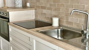 A kitchen with a stainless steel sink, a wooden countertop, and a backsplash. - P016 - Porto Recanati, new three-room penthouse 30m from the sea (Porto Recanati)