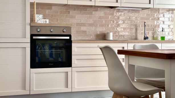 A modern kitchen with a built-in oven, white cabinetry, and a wooden countertop. - P016 - Porto Recanati, new three-room penthouse 30m from the sea (Porto Recanati)