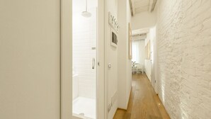 A hallway with a wooden floor, white walls, and a shower area. - Don Giovanni apartment in Florence by Mmega (Florence)