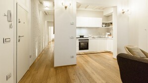 A modern kitchen with white cabinets, a stove, and a microwave. - Don Giovanni apartment in Florence by Mmega (Florence)