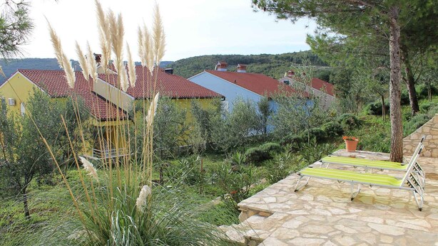 Un quartier résidentiel avec des maisons, une terrasse en pierre et une vue sur le paysage environnant.