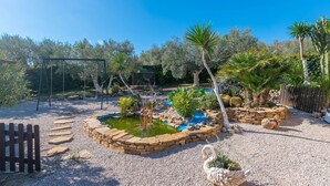 A garden with a pond, stone borders, and various plants. - Tere 2 Antequera - La Higuera by Ruralidays (Málaga)