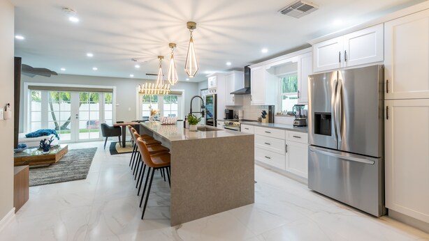 A modern kitchen with a central island, stainless steel appliances, and pendant lighting. - Modern Delray Beach Charmer - Near Atlantic Ave. in Delray Beach (Delray Beach)