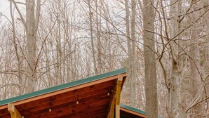 Une cabane dotée d’une terrasse en bois, d’une porte d’entrée et d’un escalier menant à un étage supérieur.