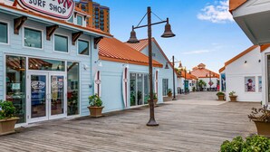 A boardwalk with a surf shop named Ron Jon Surf Shop.