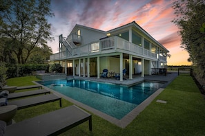 A two-story house with a swimming pool, outdoor seating, and a balcony. - Stay Salty: A Spacious 6-Bedroom Home with Marsh Views in Saint Simons Island (Saint Simons Island)