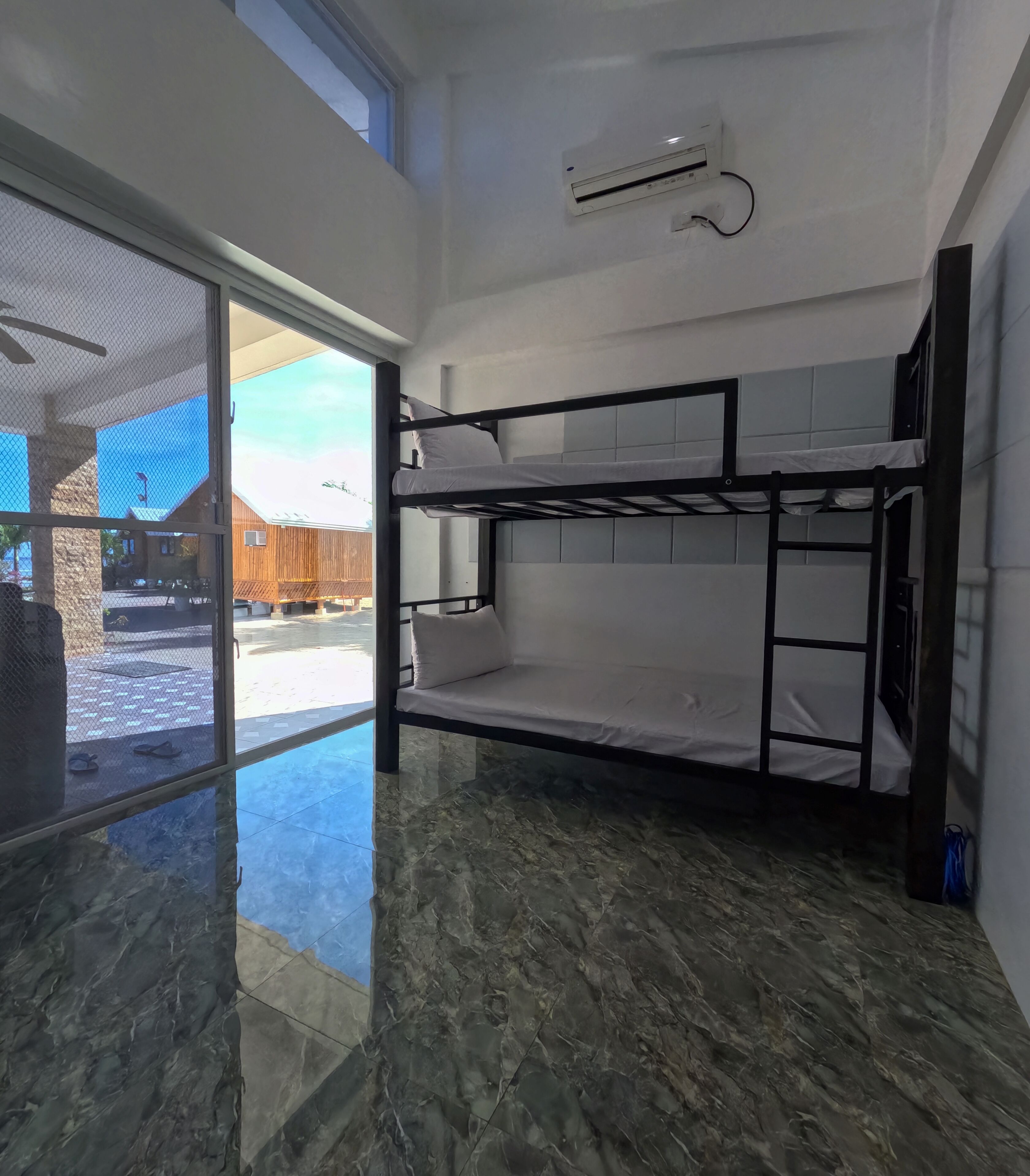 Habitación con literas, un ventilador de techo y vistas al exterior.
