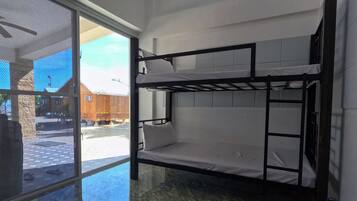 Habitación con literas, un ventilador de techo y vistas al exterior.
