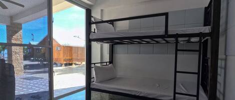 Habitación con literas, un ventilador de techo y vistas al exterior.