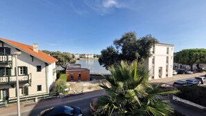 Une ville côtière avec une plage, un petit bâtiment portant l’inscription « TERME » et une route bordée de voitures garées.