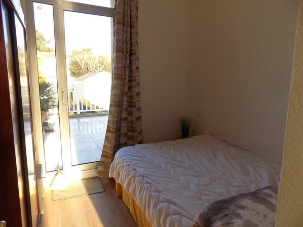 A bedroom with a bed, a window with curtains, and a view of the outside. - Saint Palais sur Mer - SUPERB INFINITELY RARE APARTMENT - LE PHALENE (ST PALAIS SUR MER)