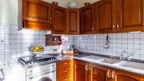Une cuisine avec des meubles de rangement en bois, une cuisinière et un évier.