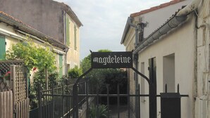Een toegangspoort met een bord waarop 'magdeleine' staat.