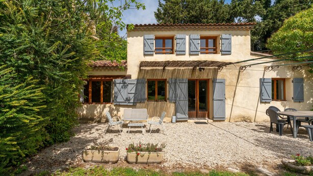 A two-story house with a patio area, outdoor seating, and potted plants. - Holiday Home 'La Petite Palasse' with Private Pool, Wi-Fi & Air Conditioning (LE THOR)