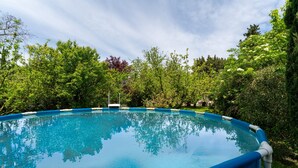 A clear blue swimming pool surrounded by lush greenery. - Holiday Home 'La Petite Palasse' with Private Pool, Wi-Fi & Air Conditioning (LE THOR)