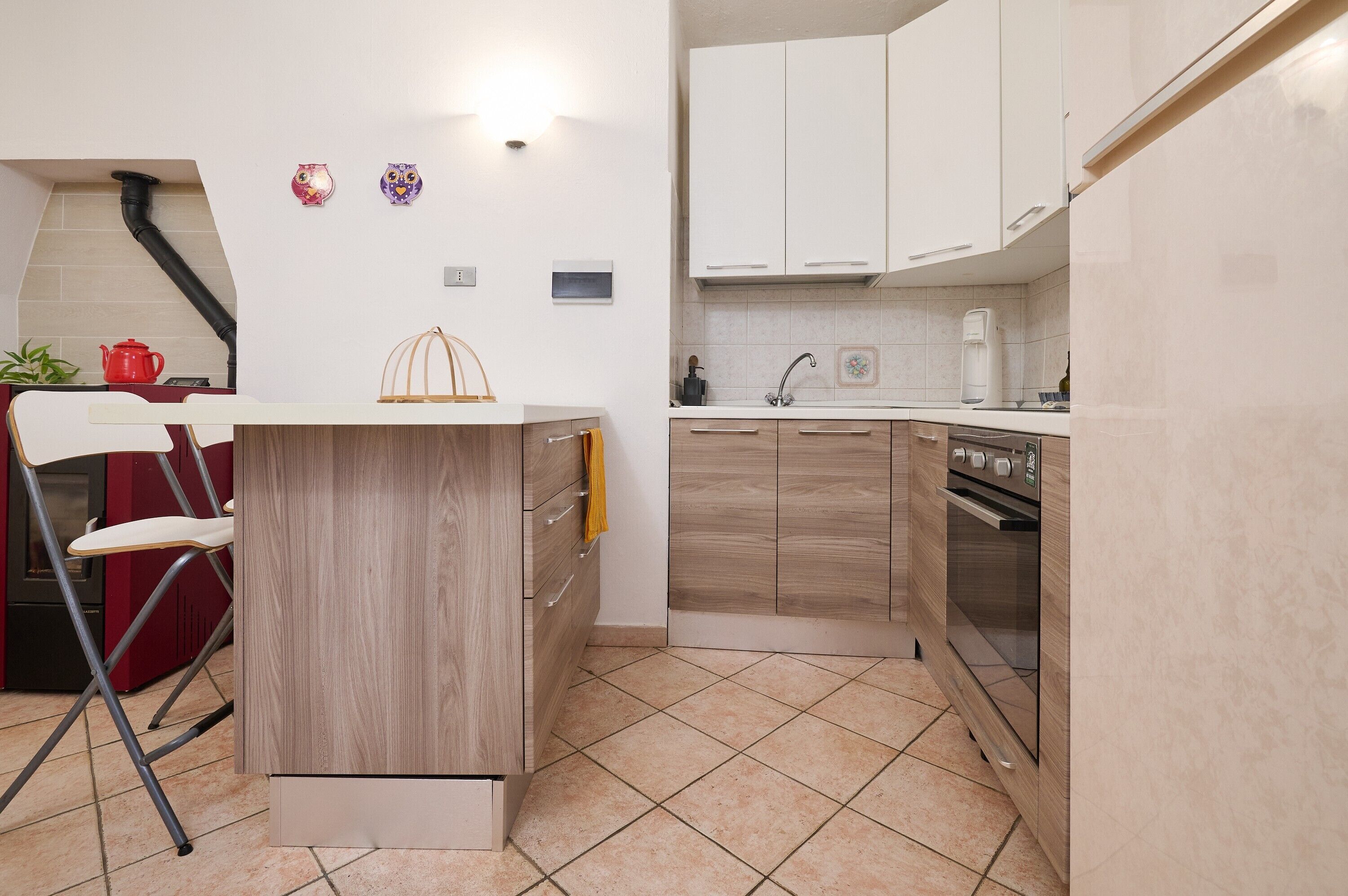 A compact kitchen with a foldable dining table, a built-in oven, and a sink.