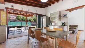 Una cocina moderna con comedor, vigas de madera en el techo y vistas al exterior.