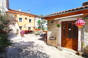 A narrow street with a stone building, a wooden door, and a colorful hanging lantern. - Holiday apartment with air conditioning (Krnica)